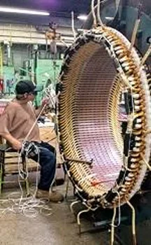 A worker weaves a large, circular basket on a machine, with colorful cords and intricate patterns visible in the craftsmanship