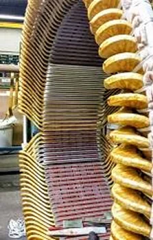 Close-up of stacked electrical coils, showcasing layers of insulated wire wrapped in yellow and red, forming a large cylindrical shape